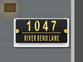Modern black and gold mirror address sign 1047 shown installed on a contemporary home exterior