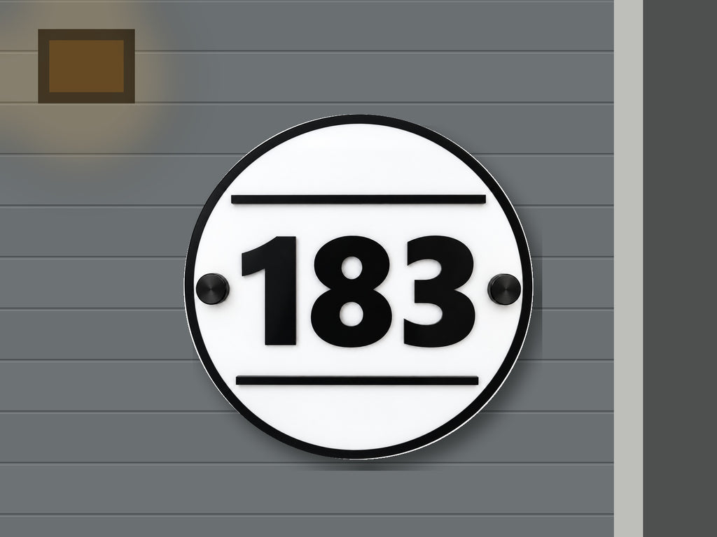 Round modern black and white address sign 183 shown installed on a contemporary home exterior