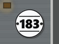 Round modern black and white address sign 183 shown installed on a contemporary home exterior